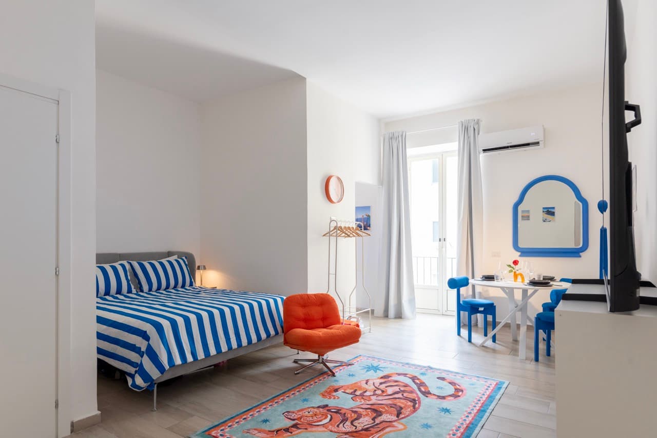 Studio overview with striped bed and tiger rug